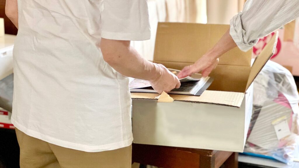 家族で段ボール箱に品物を詰めながら整理している様子